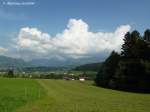 Frisch gemäht ist diese Wiese unterhalb des Gasthofes  Bergwirt  in Hüttenberg bis hinunter an die Häuser von Westerhofen. Über den Bergen türmen sich Wolkenberge (Oberallgäu - August 2010)