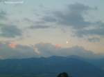 Von der letzten Sonne am Abend beleuchtete Wolken sowie der Fast-Vollmond kurz vor dem Monduntergang über der Bergkette  Hörner  westlich des Illertales (Oberallgäu - August 2010)