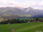 Das Tal ist bereits halb im Schatten: Sonnenköpfe, daneben Nebelhorn und Rubihorn - auf halber Höhe die Ortschaften Schöllang und Reichenbach, erreichbar auf der Nebenstrecke von Sonthofen nach Oberstdorf (Oberallgäu, Juli 2008)