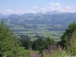 Über das Illertal hinweg ist Sonthofen-Altstädten zu erkennen und dahinter die Sonnenköpfe (Landkreis Oberallgäu, Sommer 2009)