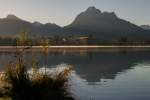 erste Sonnenstrahlen kommen ber die Alpgipfel am Morgen auf den Hopfsee bei Fssen, 18.10.13