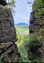 Durch die Felsen des Pfaffensteins gelugt: auf Pfaffendorf (Königstein) und den Lilienstein.