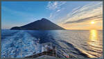 Blick vom Fährschiff Laurana auf die Vulkaninsel Stromboli, die von der Morgensonne beleuchtet wird.