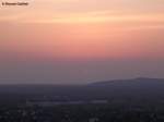 Blick über Bottrop hinweg nach Westen mit der fast veschwundenen Sonne (Ruhrgebiet - April 2010)