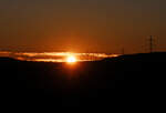 Sonnenuntergang mit Hochspannungsleitung im letzten Licht über der Eifel - 09.01.2024