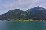 Schifffahrt über den Achensee, Blick von der Seespitz aus auf das Ufer und die Berge nahe Buchau, dessen Badestrand und Segelbootshafen.